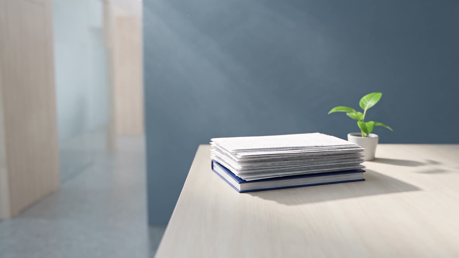A neat stack of receipts on a blue ledger, on a bright desk in morning light